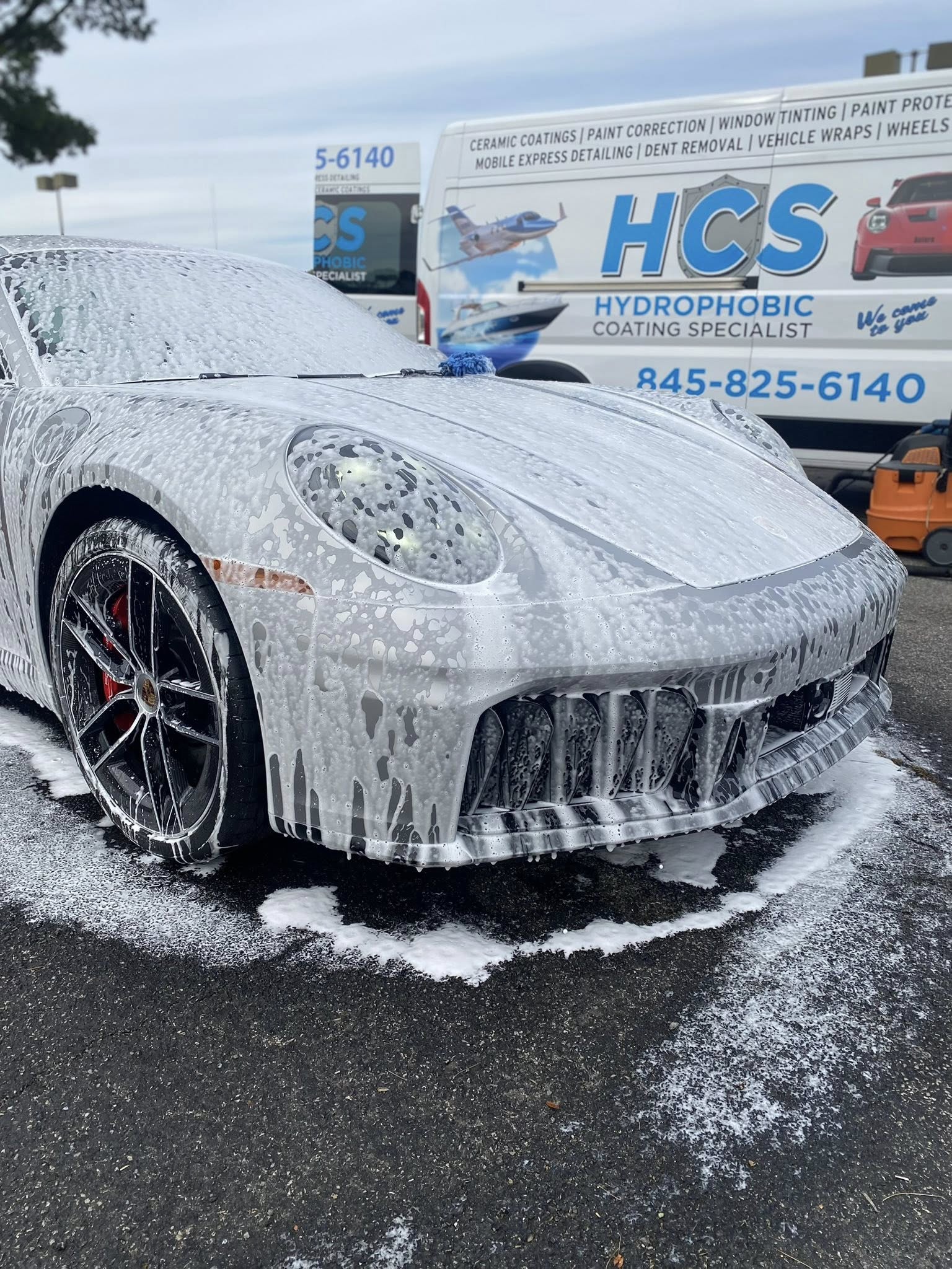 Porsche being hand-washed during exterior detailing